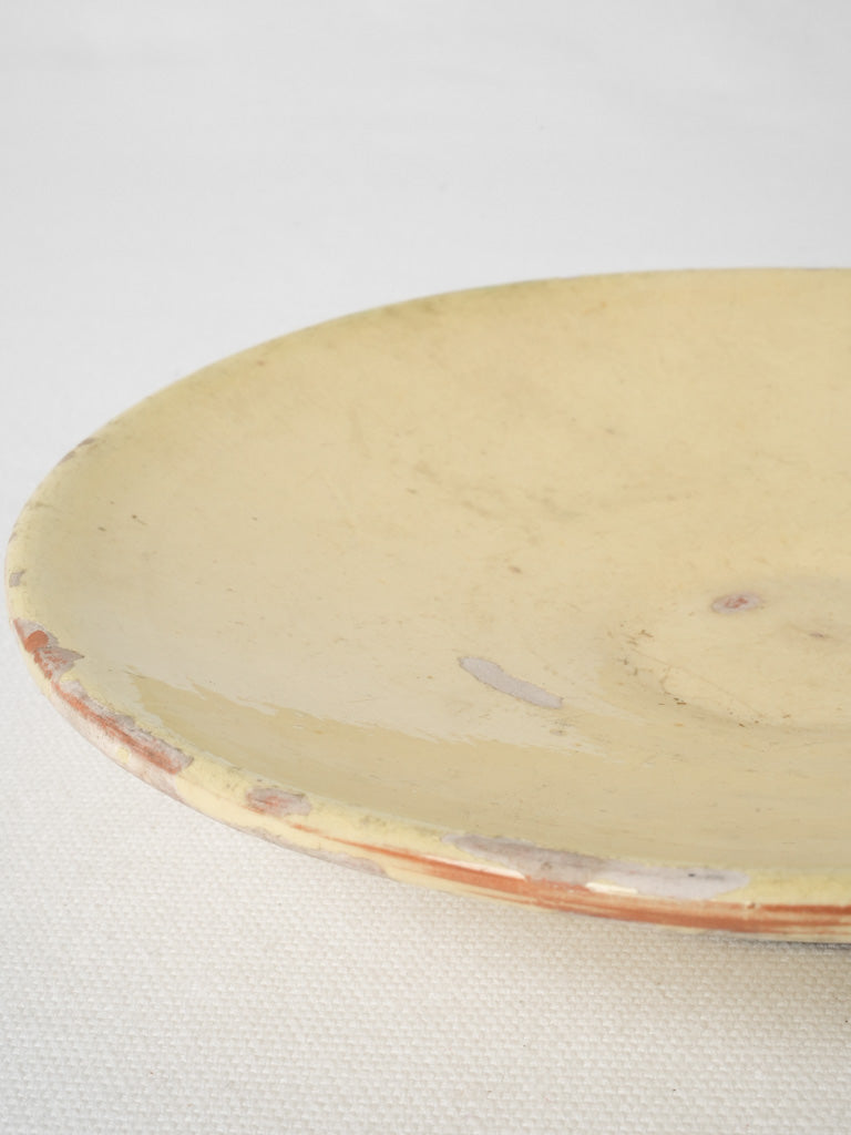 Pale yellow, footed French pottery plate