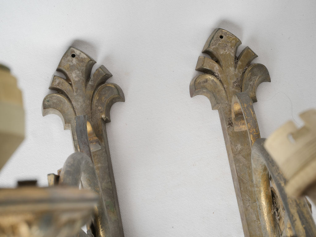 Intricate fleur-de-lis brass sconces