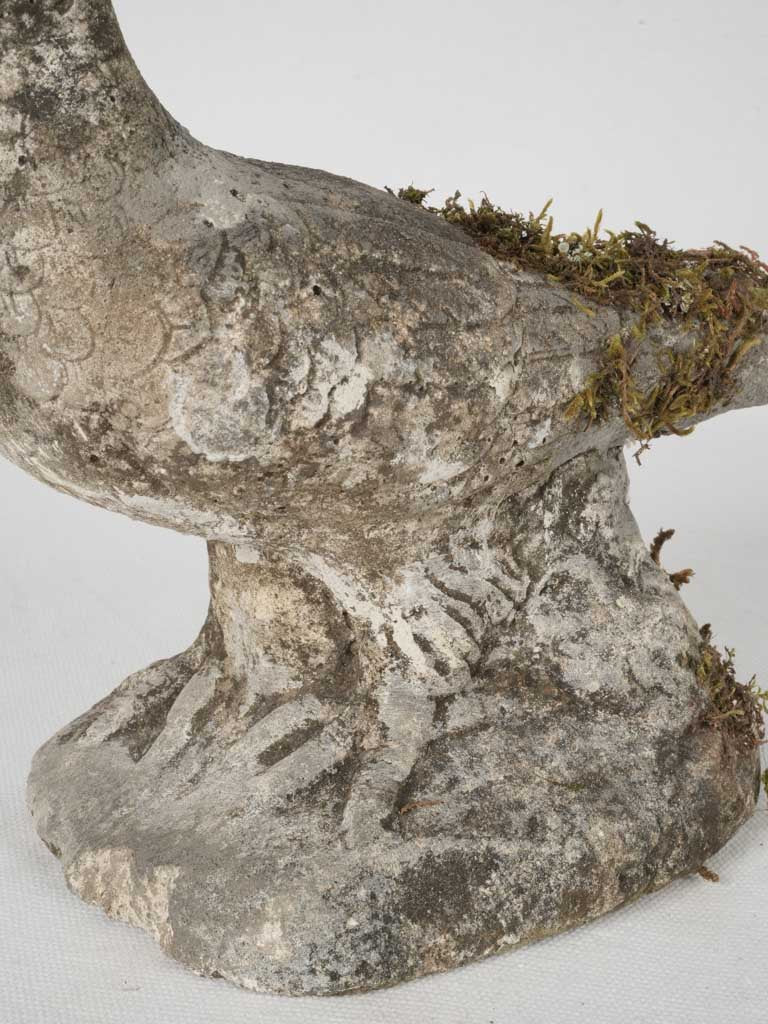 Moss-covered antique bird sculpture