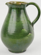 Glossy, bulbous, green-glazed ceramic pitcher