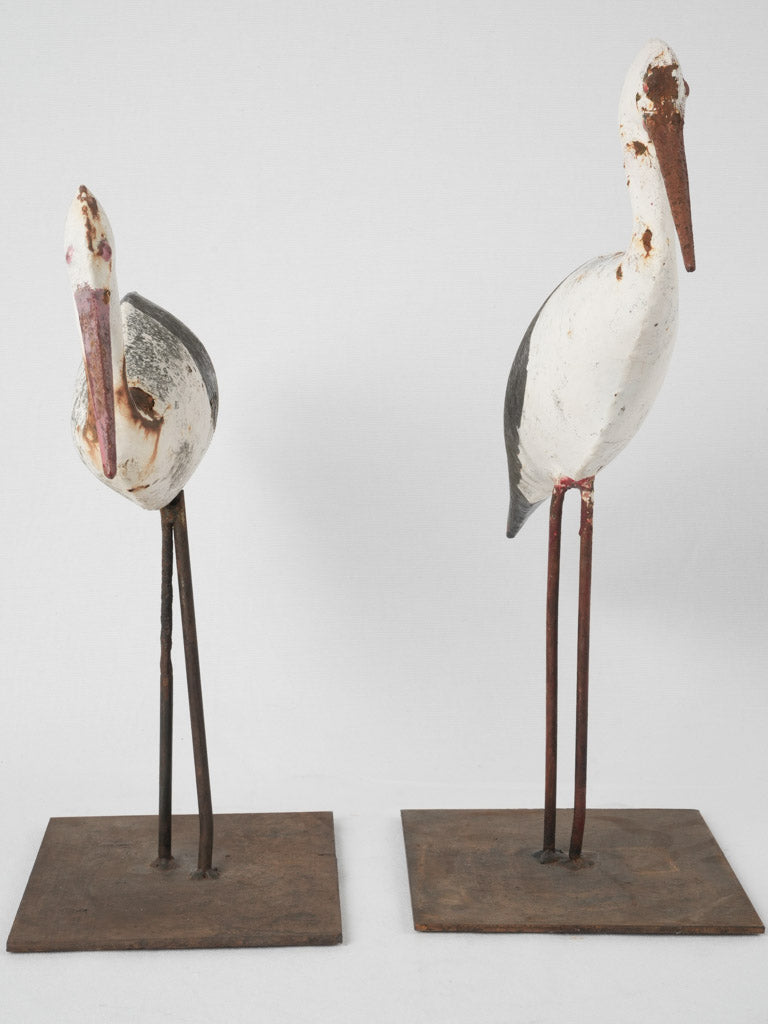 Rustic, hand-painted metal stork figurines