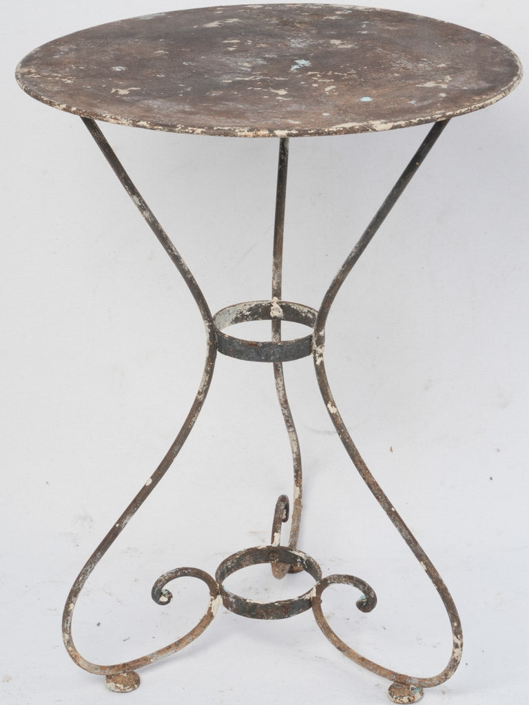 Aged, double-braced iron outdoor table