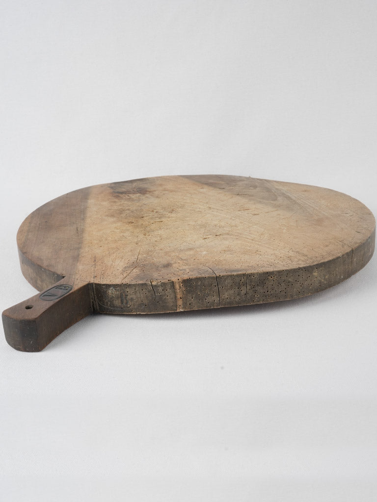 Aged, decorative walnut round cutting board