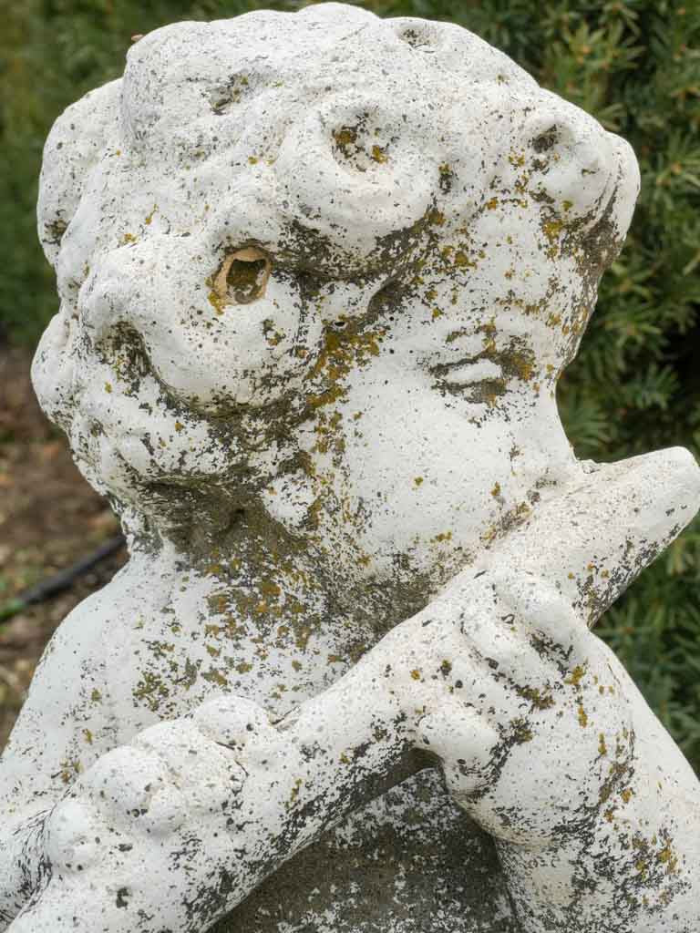 Aged garden sculpture of chubby cherub