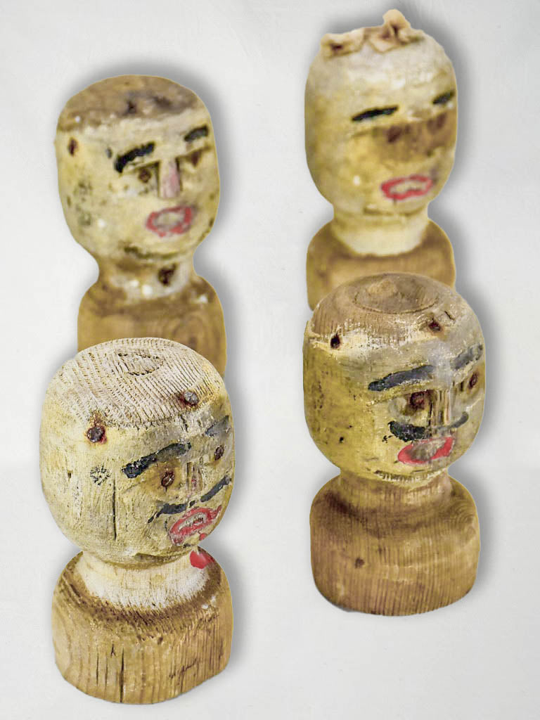 Four antique carved wooden heads from a French game