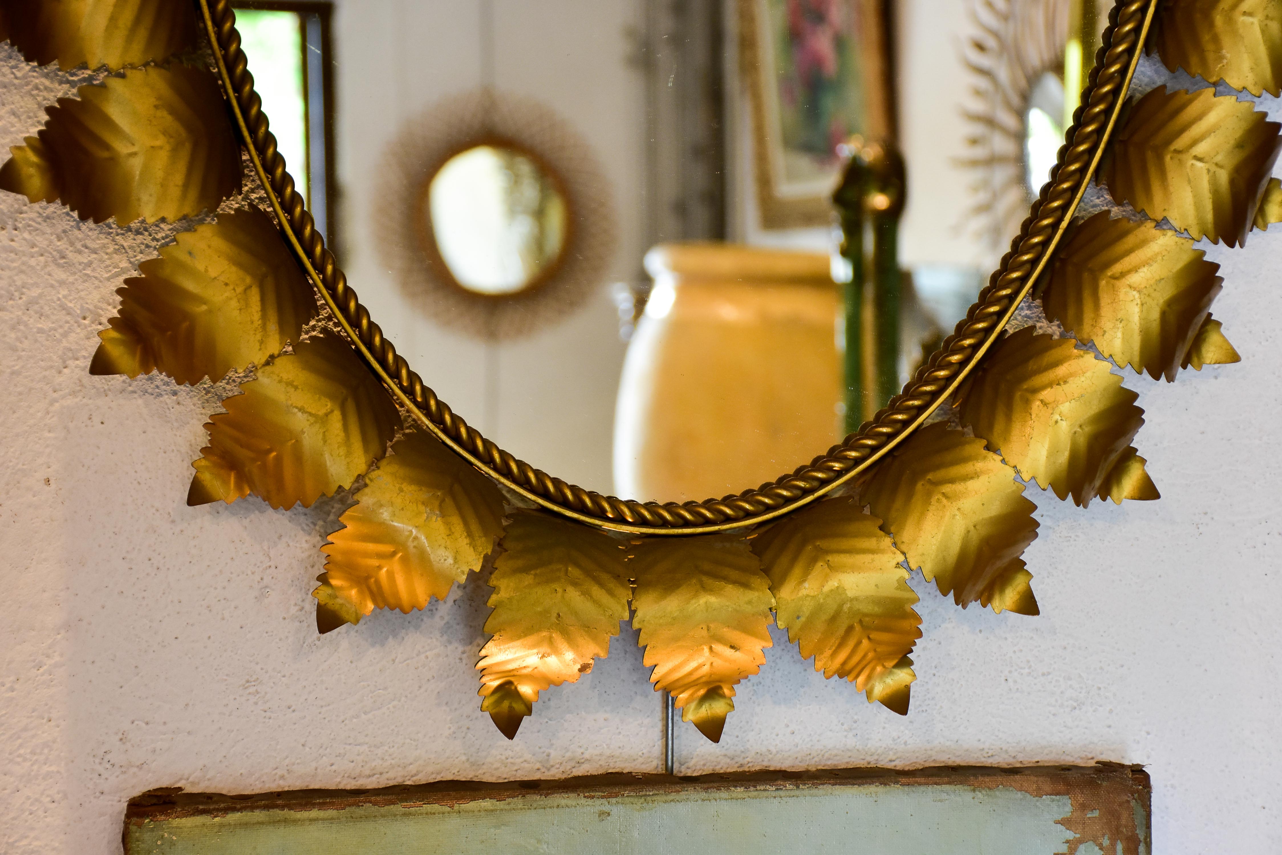 Oval sunburst mirror with sculptural leaf frame