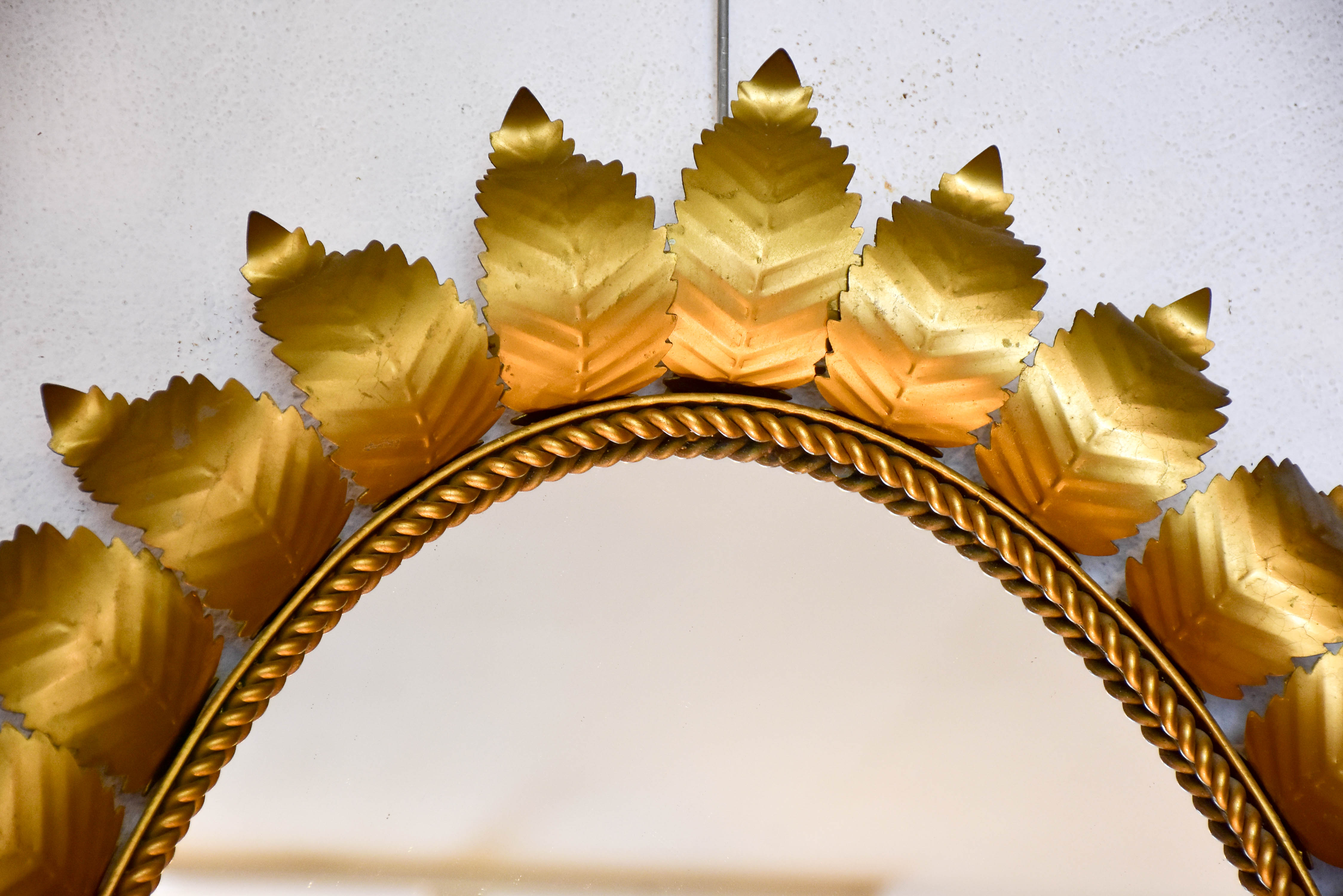 Oval sunburst mirror with sculptural leaf frame