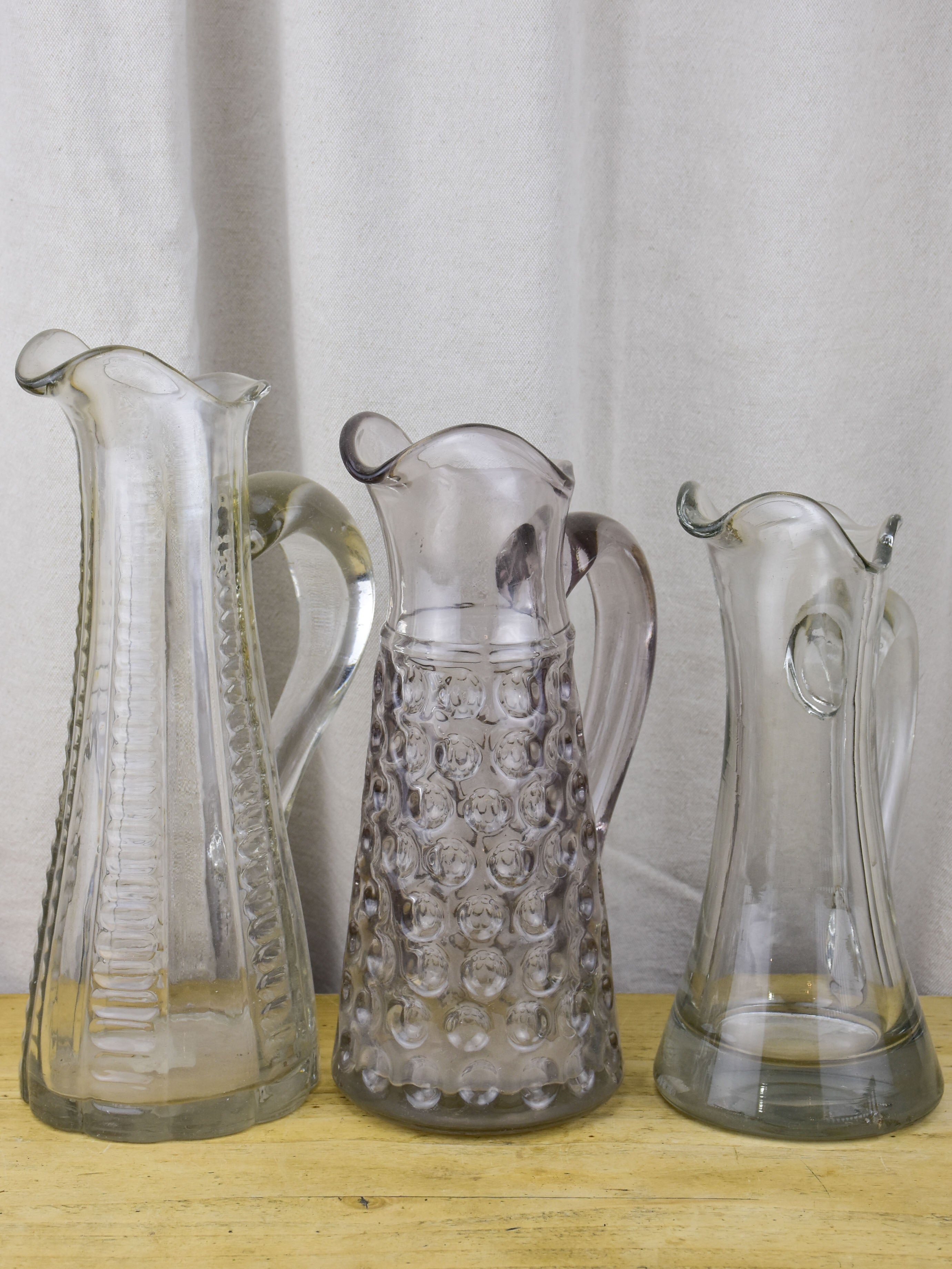 Three antique French pitchers with hand blown glass