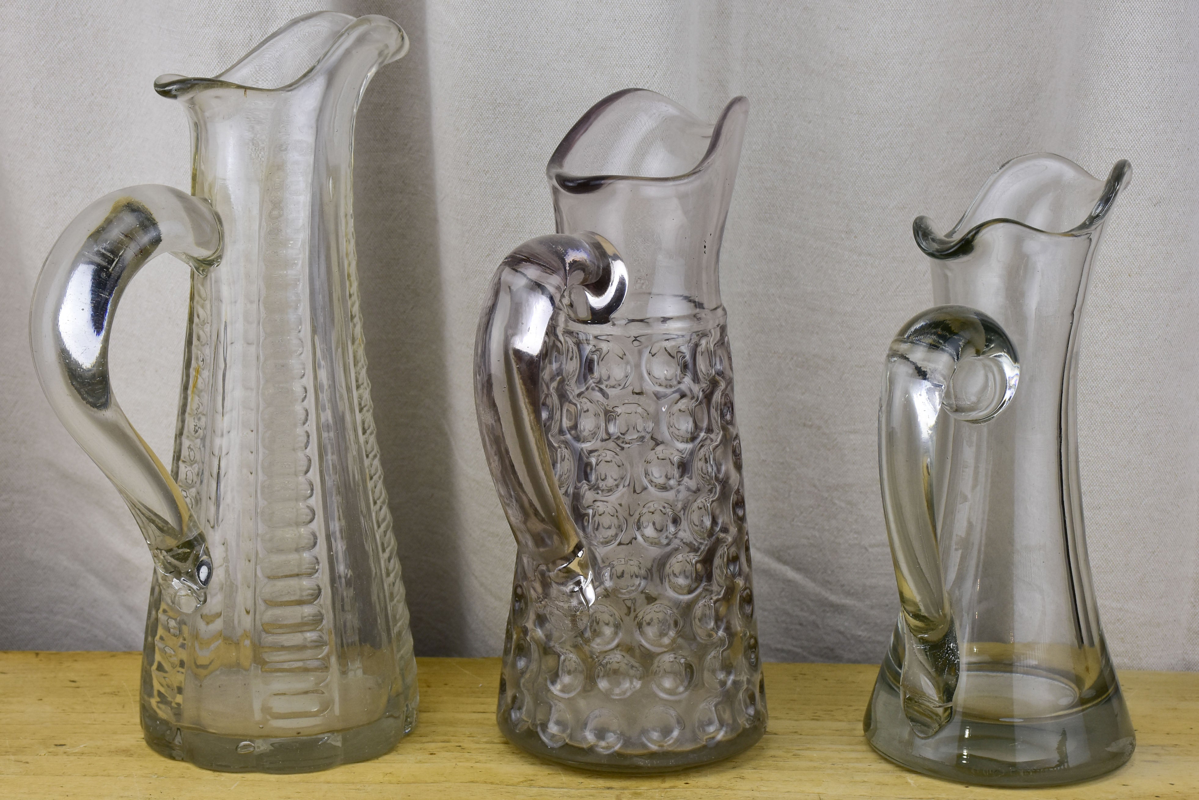 Three antique French pitchers with hand blown glass