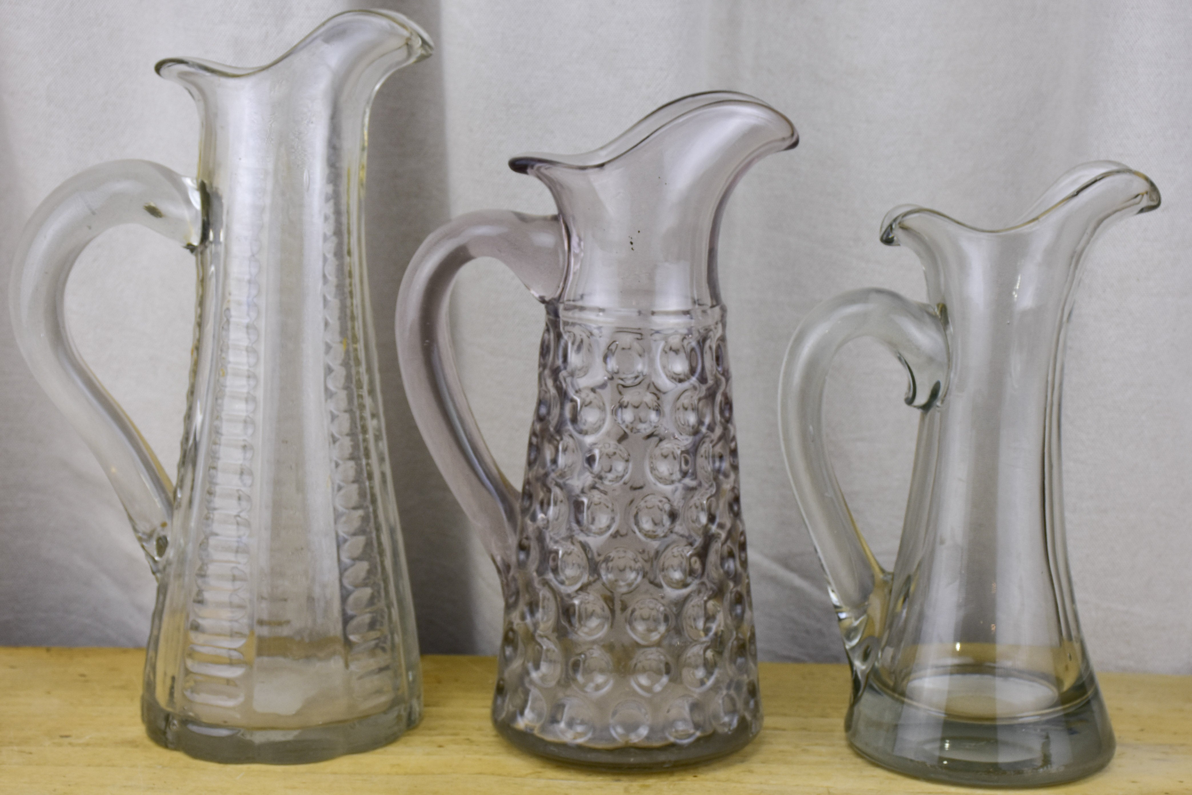 Three antique French pitchers with hand blown glass