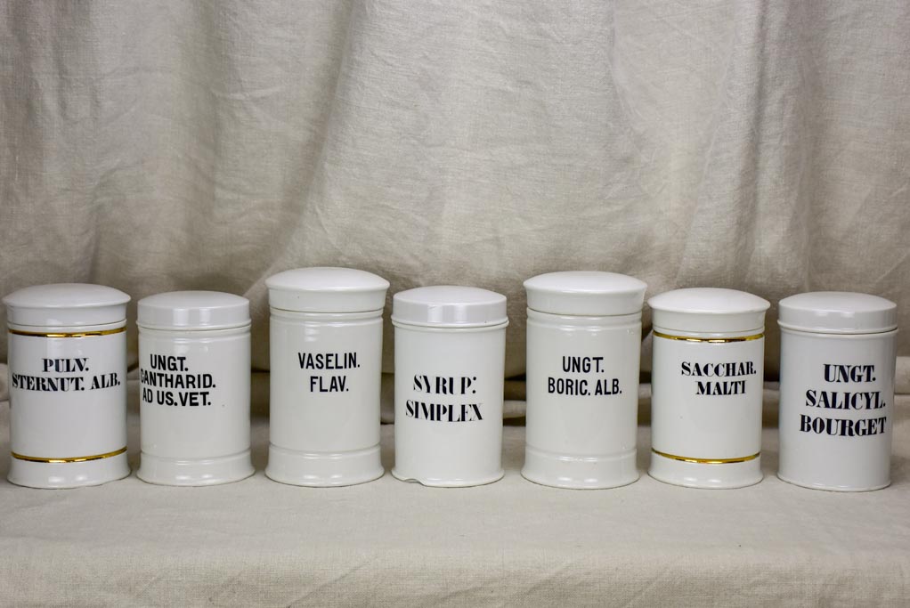 Collection of 7 white antique French apothecary jars with lids