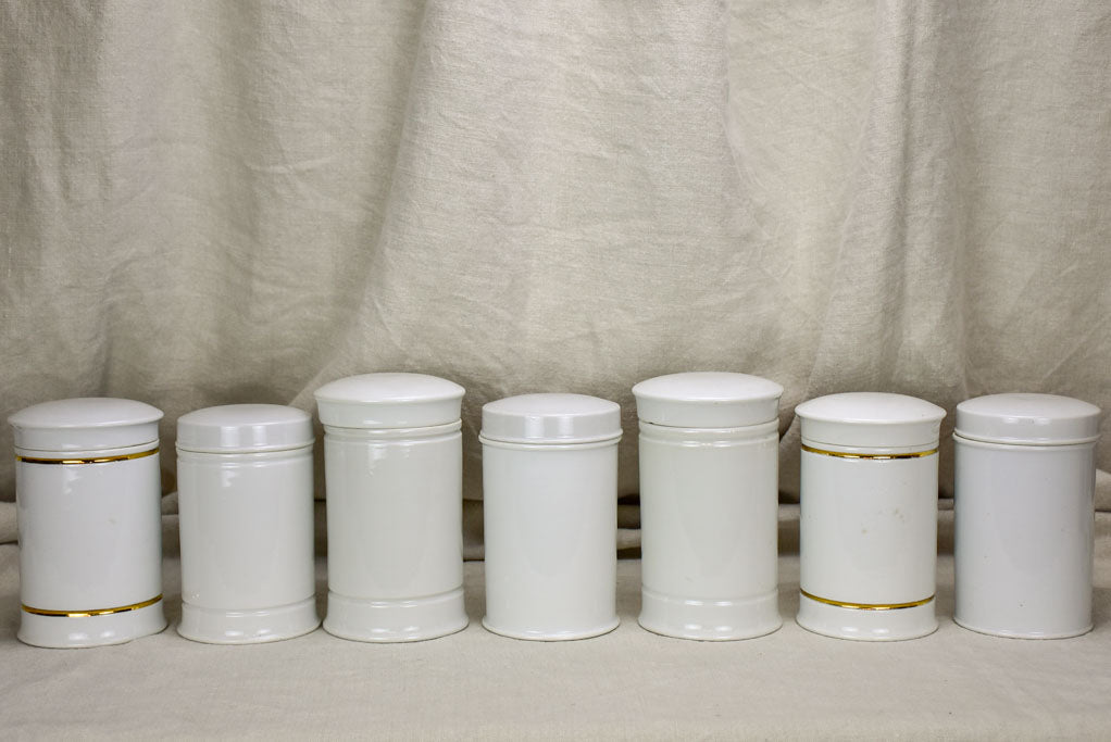 Collection of 7 white antique French apothecary jars with lids