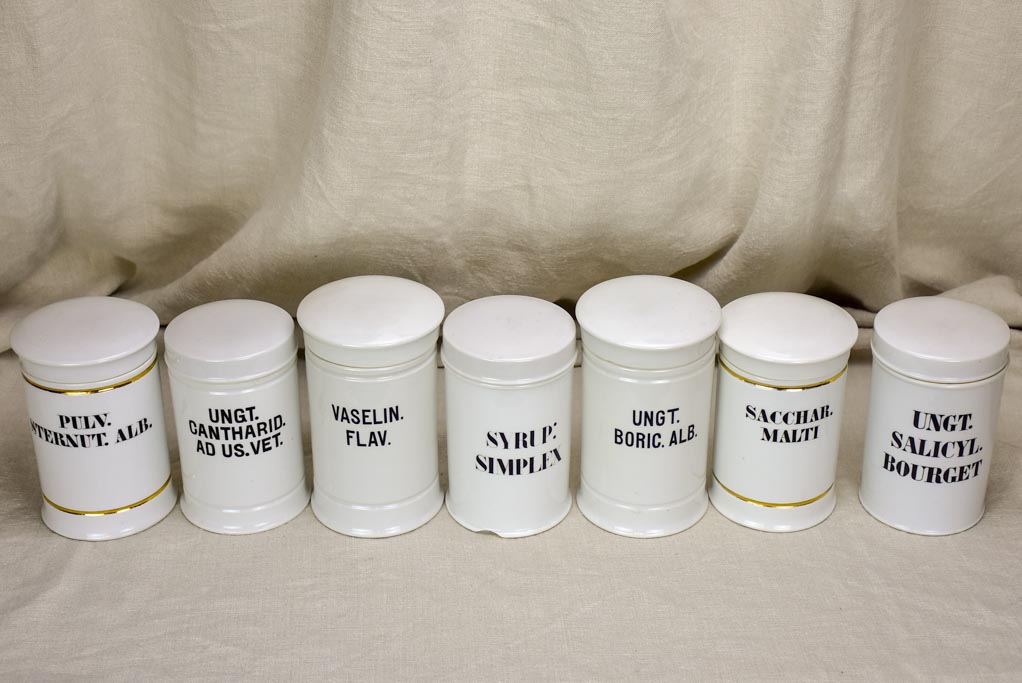 Collection of 7 white antique French apothecary jars with lids