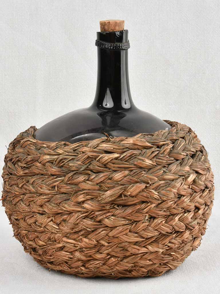 Small demijohn bottle in woven straw basket 11½"