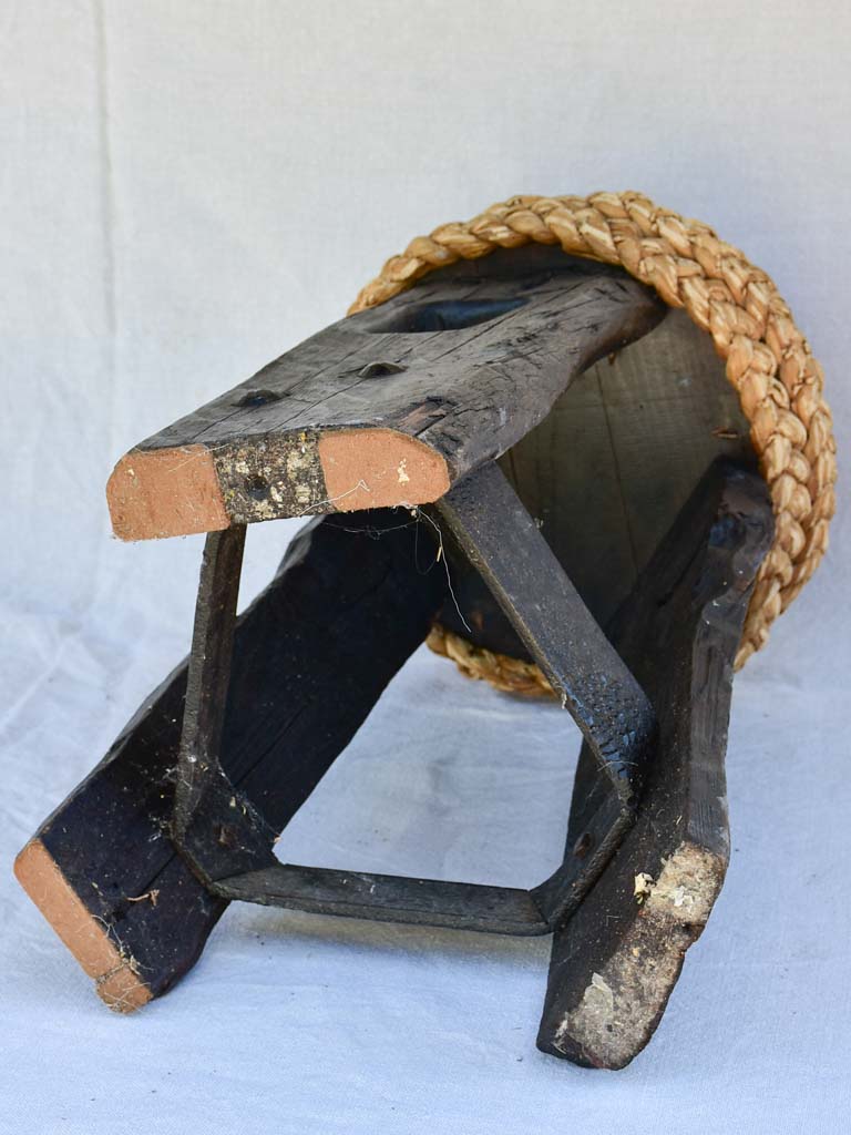 Three 1960's stools with woven seats and weighty timber and iron bases