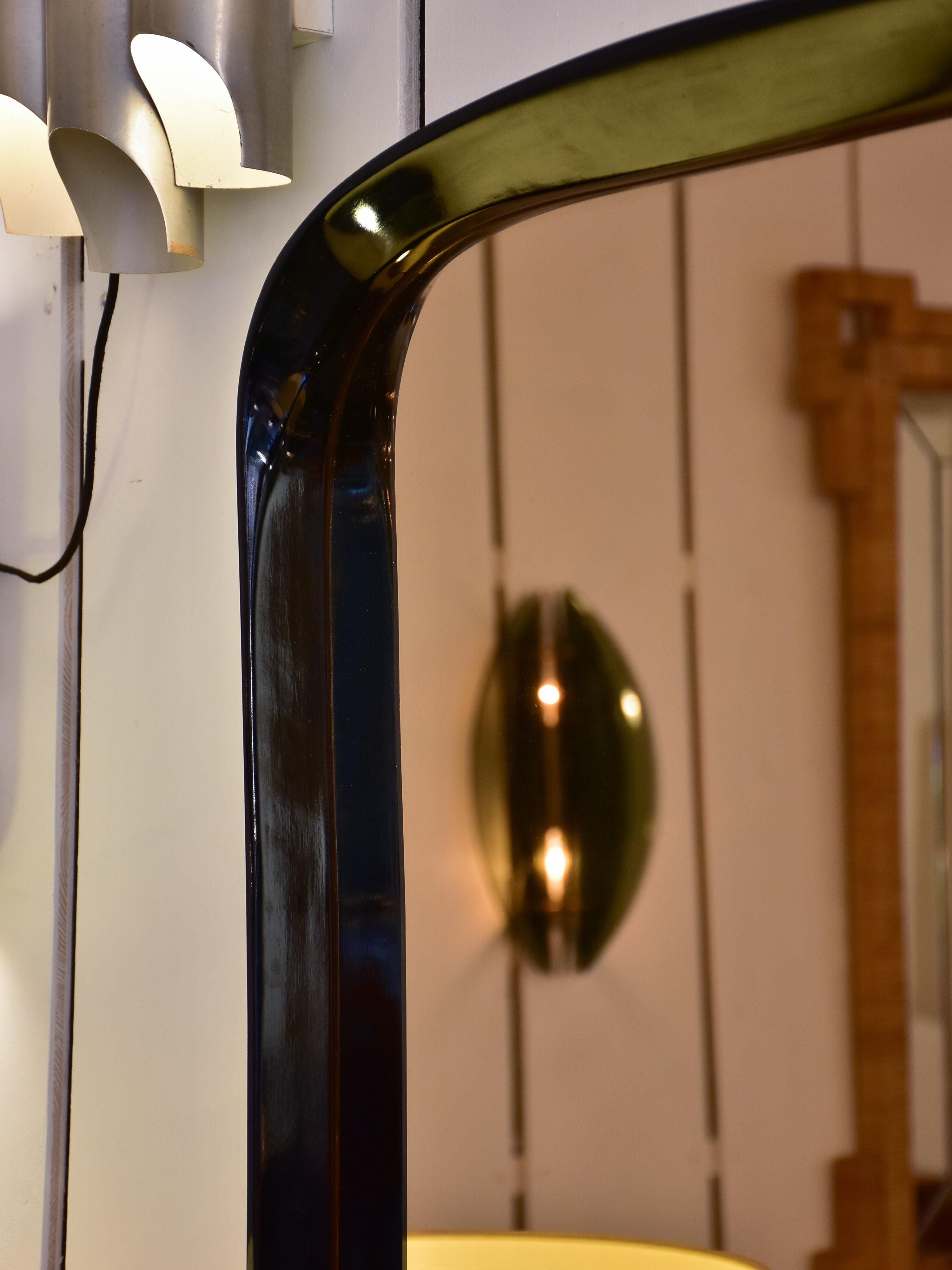 Mid century mirror with curved black frame and amber glass