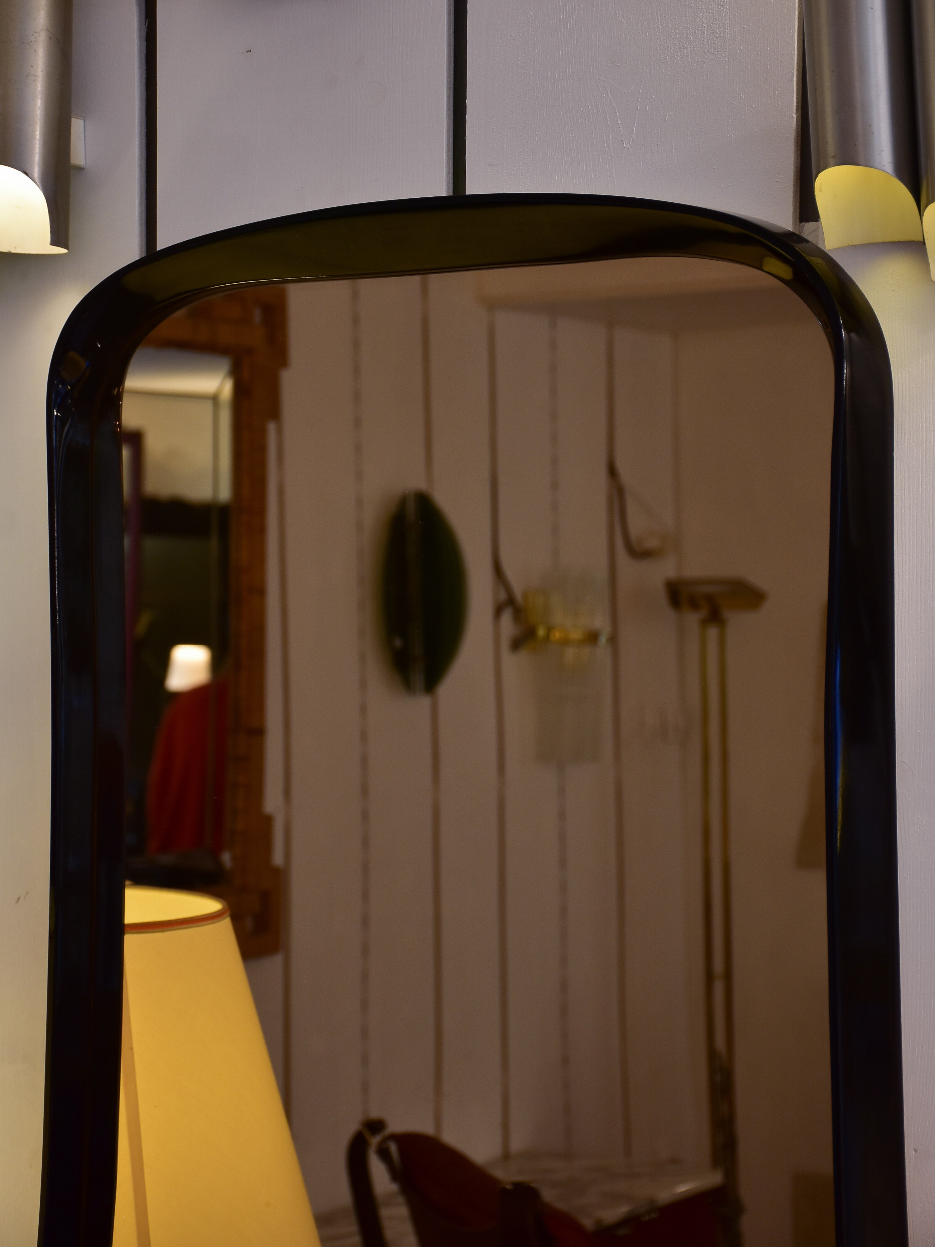 Mid century mirror with curved black frame and amber glass