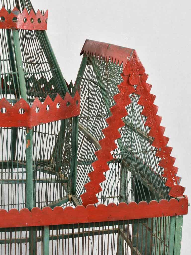 Antique birdcage with red paint accents