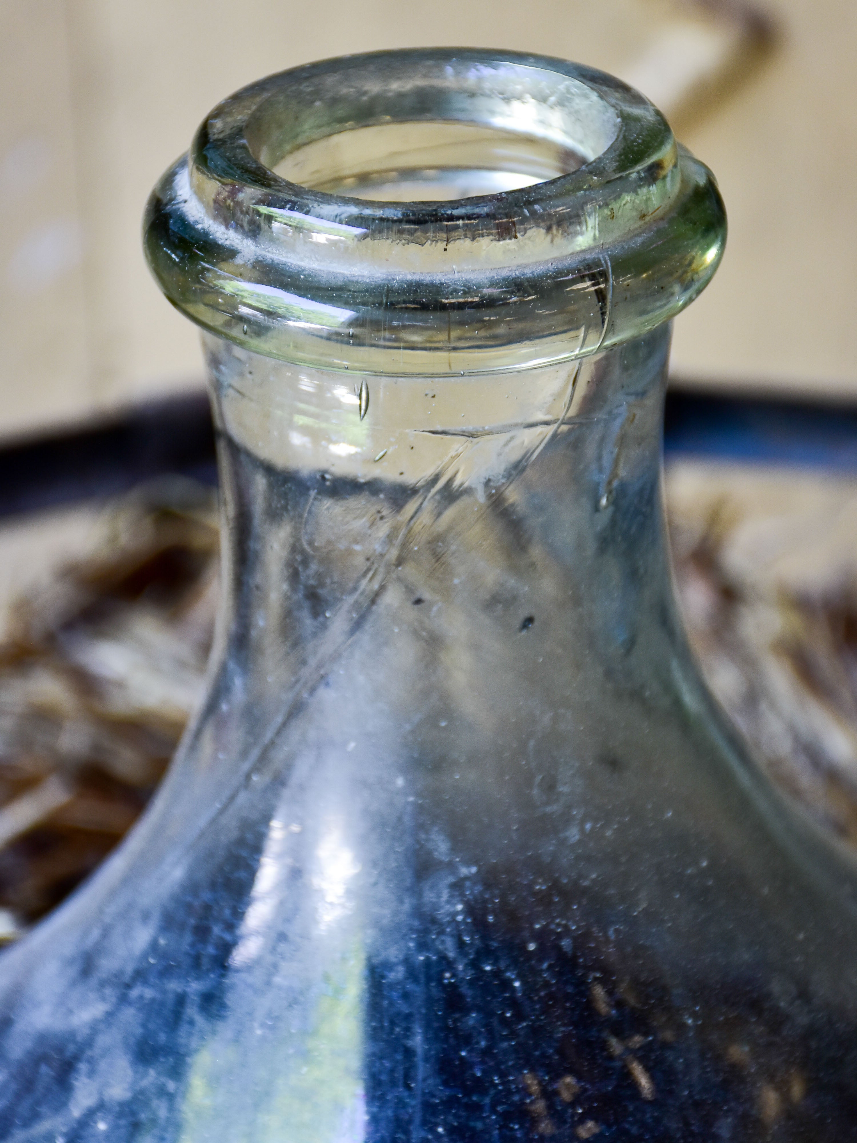 Very large antique French demijohn bottle in hay and crate