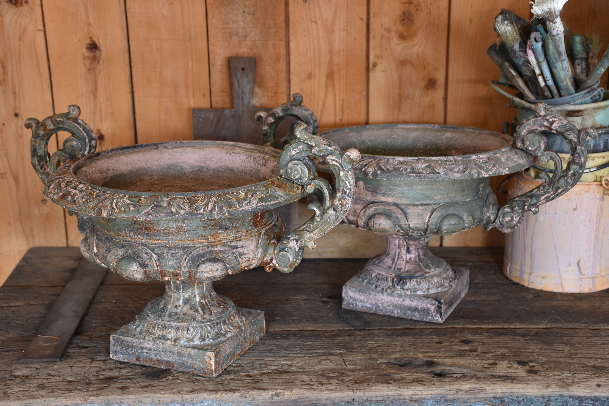 Pair of antique Medici urns with green / pink patina