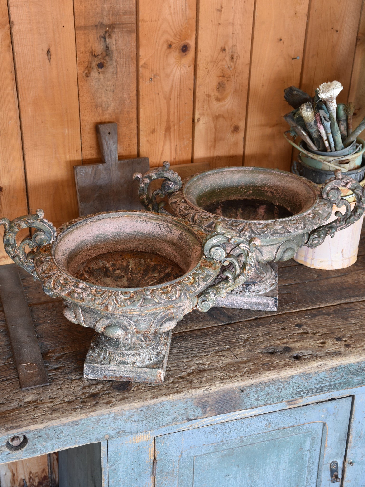 Pair of antique Medici urns with green / pink patina