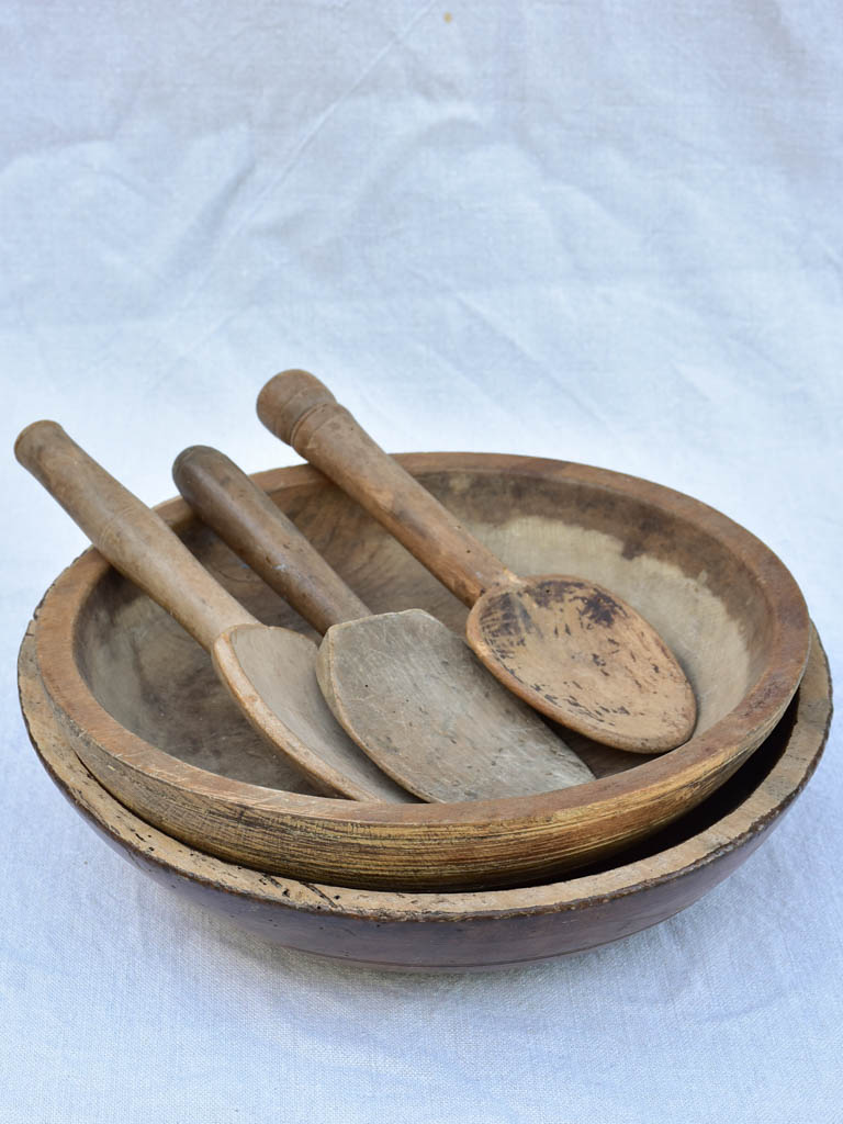 Two primitive wooden cream bowls with three spoons from Angers