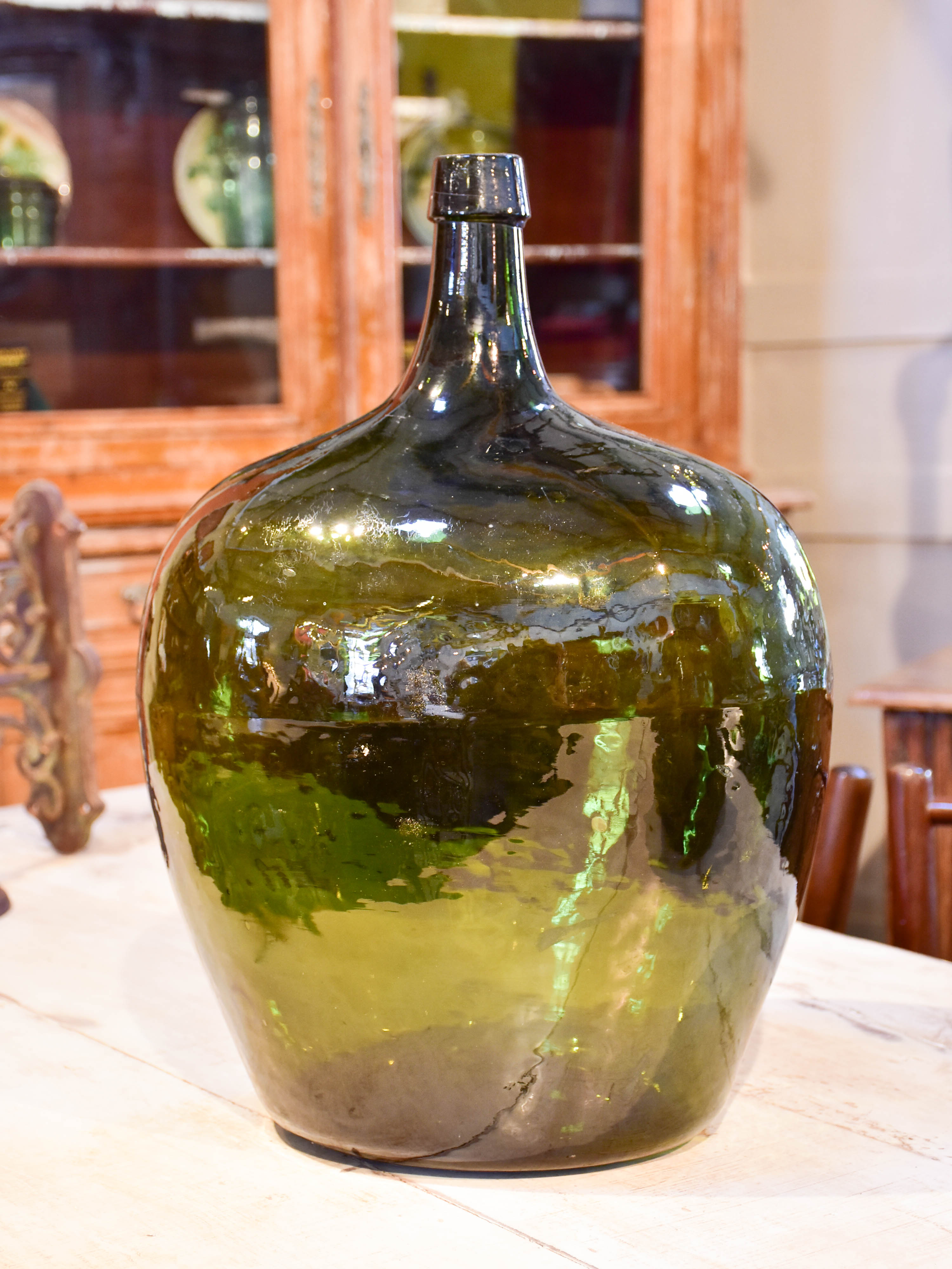 Large oval demijohn with dark green glass