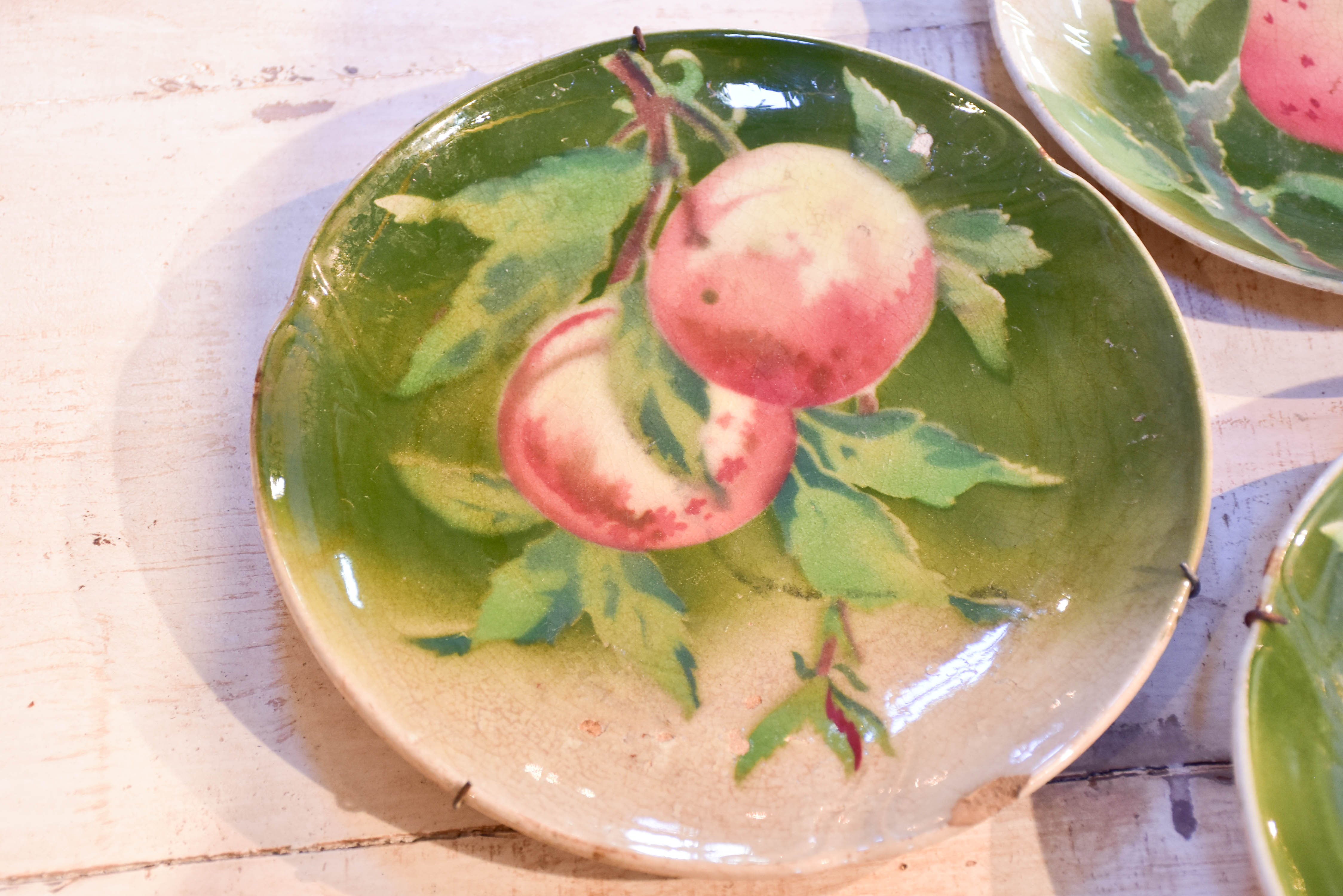 Three antique Gien plates with fruit