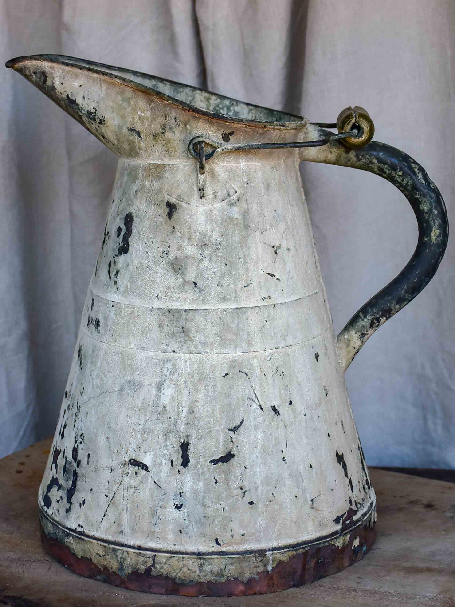 Antique French watering can with beige patina