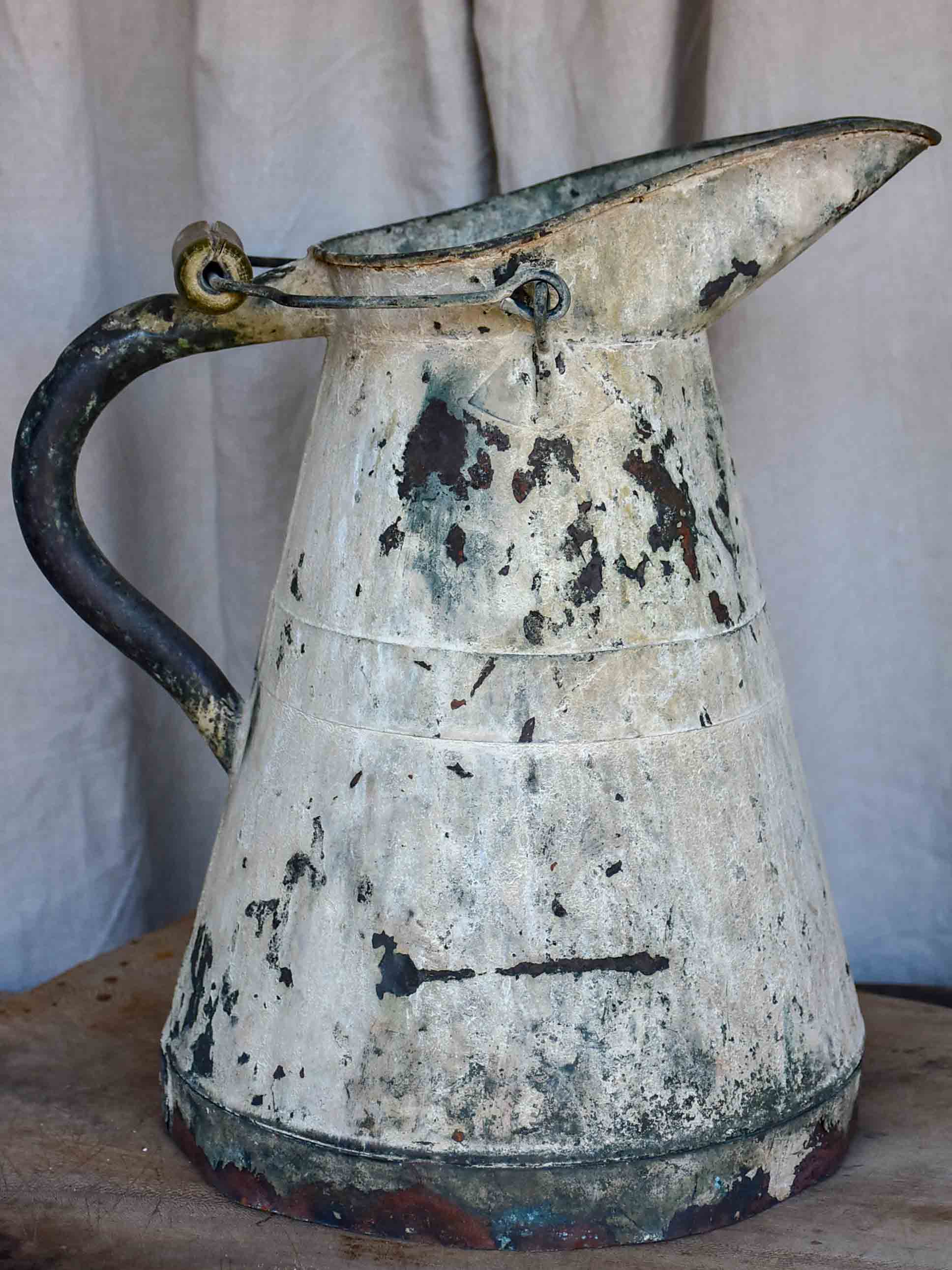 Antique French watering can with beige patina