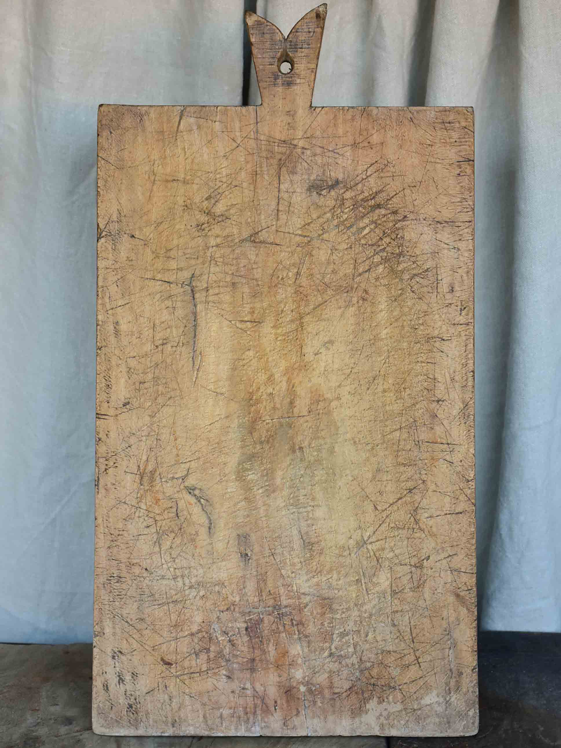 Very large antique French cutting board with fishtail handle