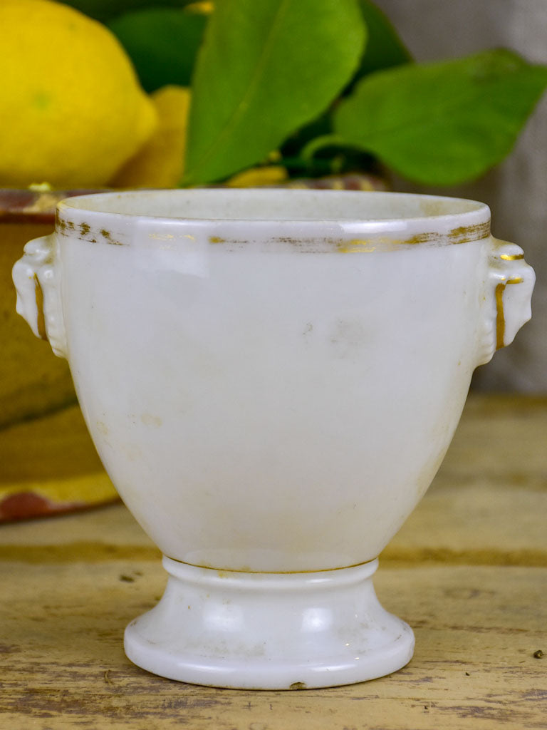 Antique French earthenware cup with face handles and gold trim