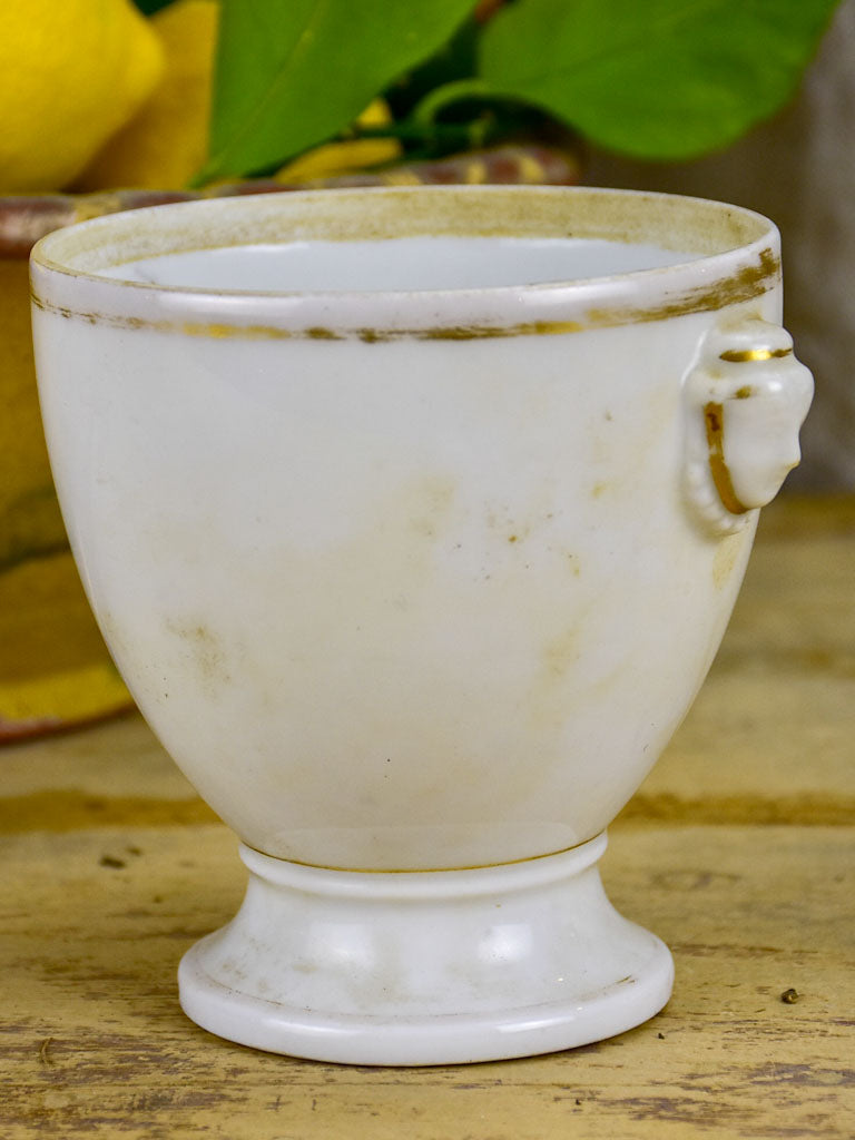 Antique French earthenware cup with face handles and gold trim