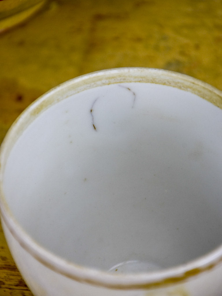 Antique French earthenware cup with face handles and gold trim