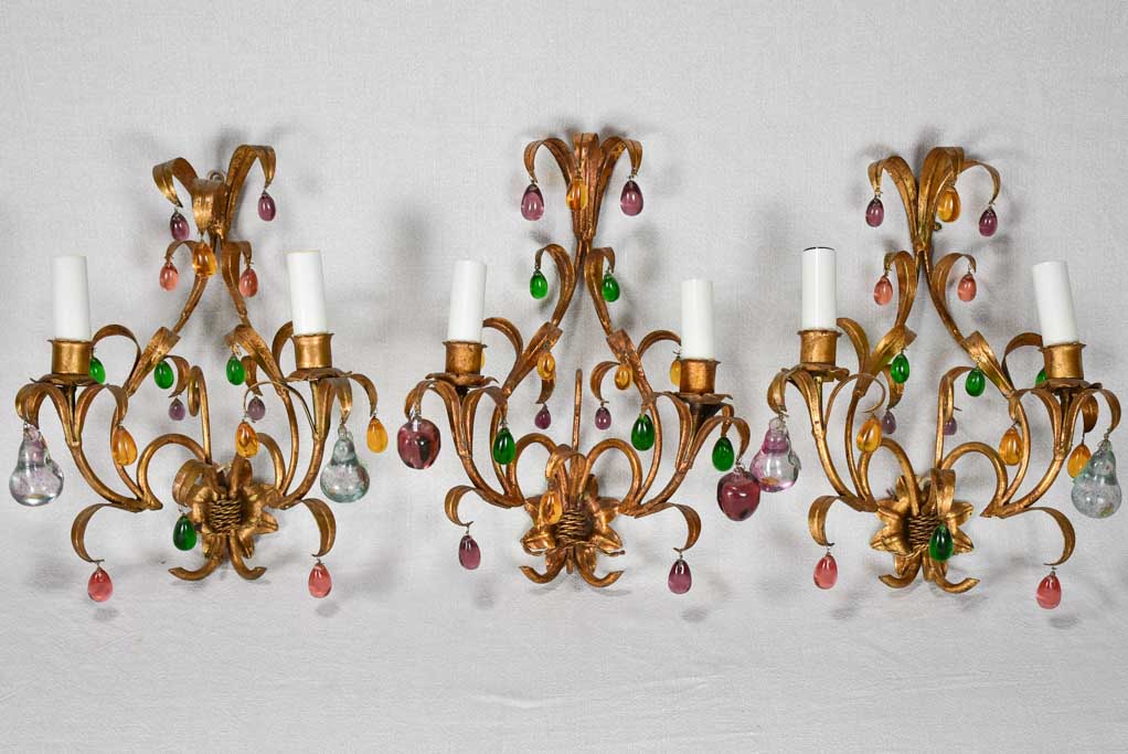 Three gold 1950s wall sconces with colorful glass fruits and pendants 13¾"