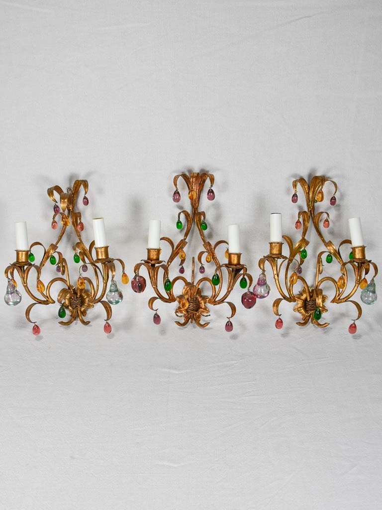 Three gold 1950s wall sconces with colorful glass fruits and pendants 13¾"