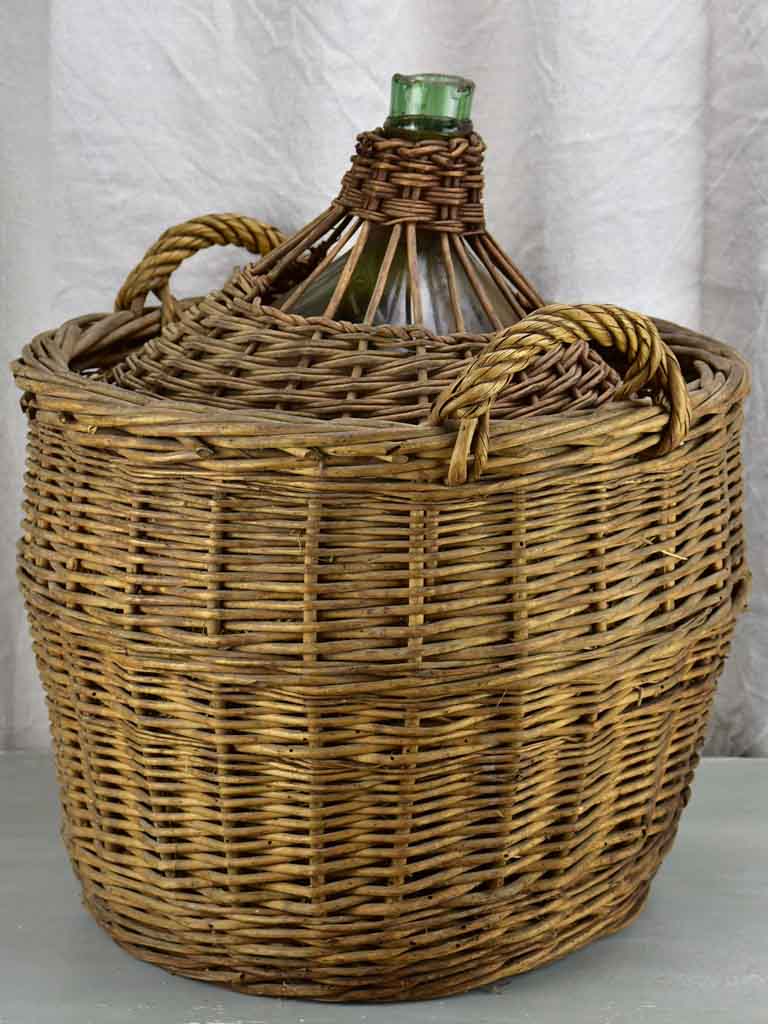 Very large antique French demijohn in a basket