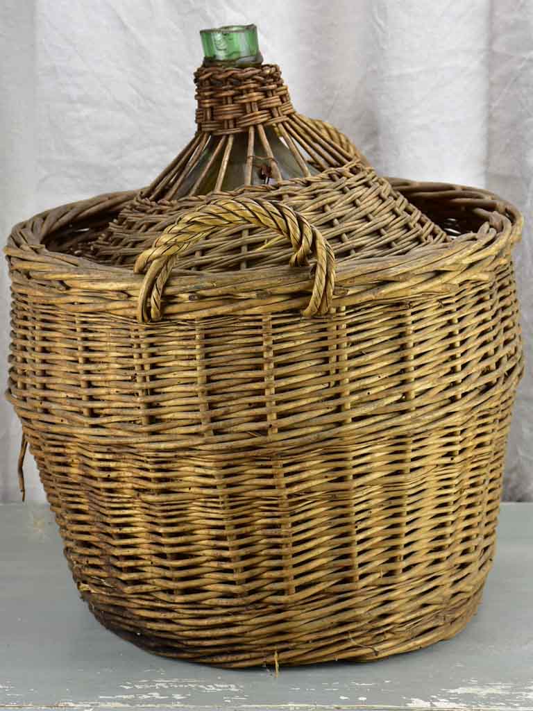 Very large antique French demijohn in a basket