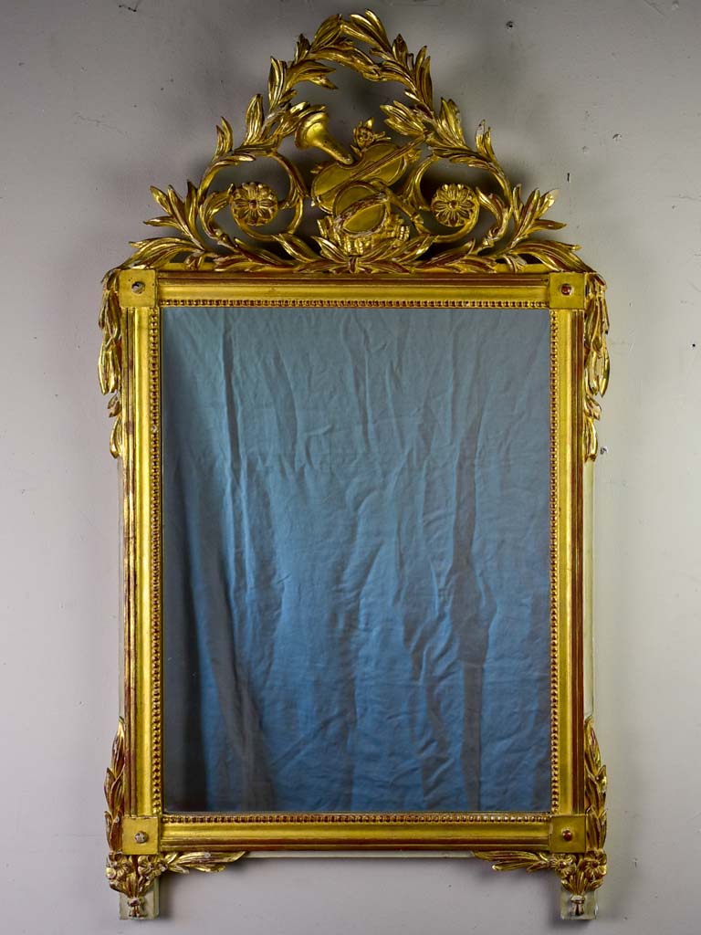 Louis XVI-style gilded mirror with musical floral crest and motifs 26½" x 46¾"