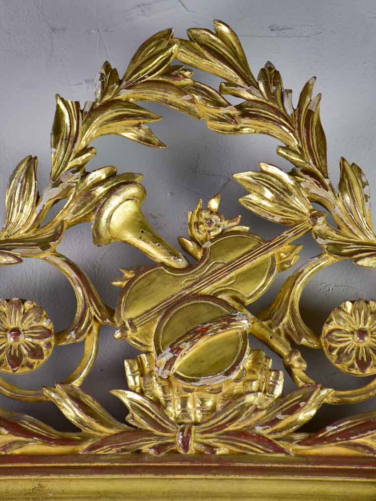 Louis XVI-style gilded mirror with musical floral crest and motifs 26½" x 46¾"