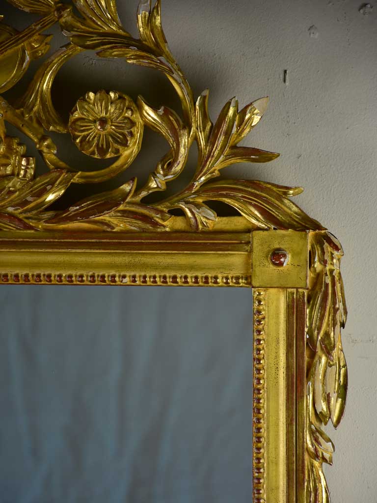 Louis XVI-style gilded mirror with musical floral crest and motifs 26½" x 46¾"