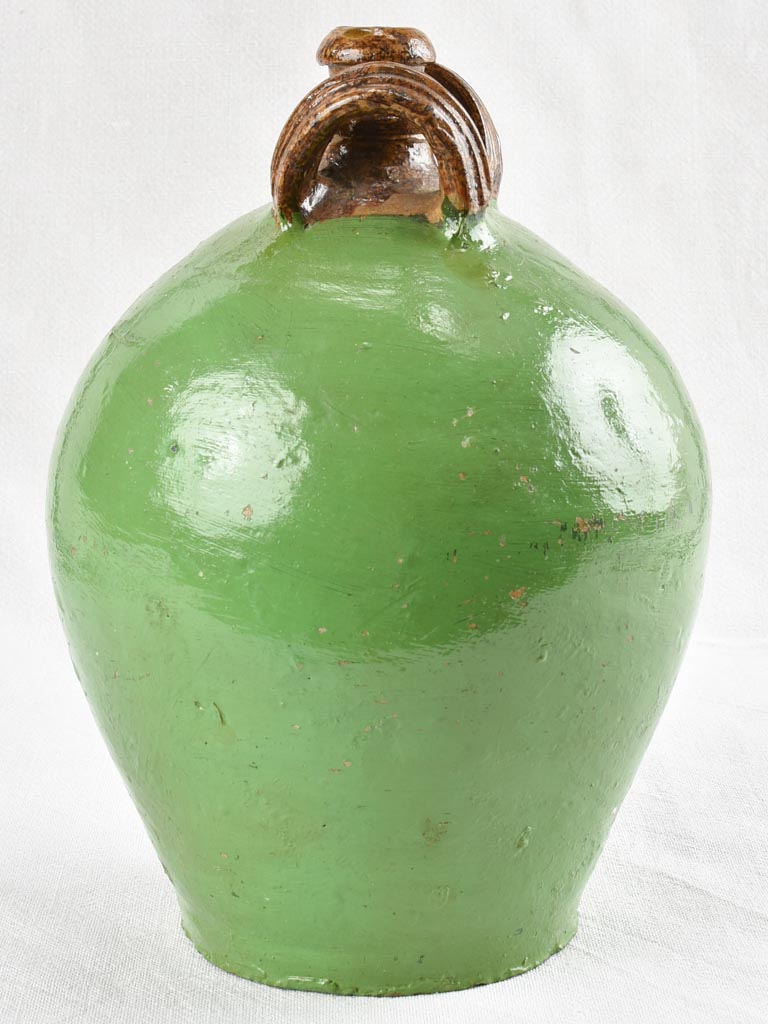 Antique water jug with green paint finish