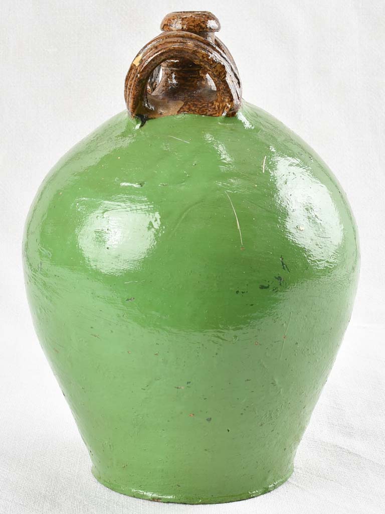 Antique water jug with green paint finish