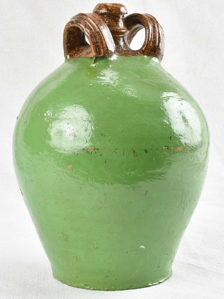 Antique water jug with green paint finish