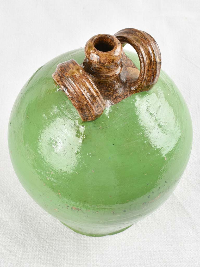 Antique water jug with green paint finish