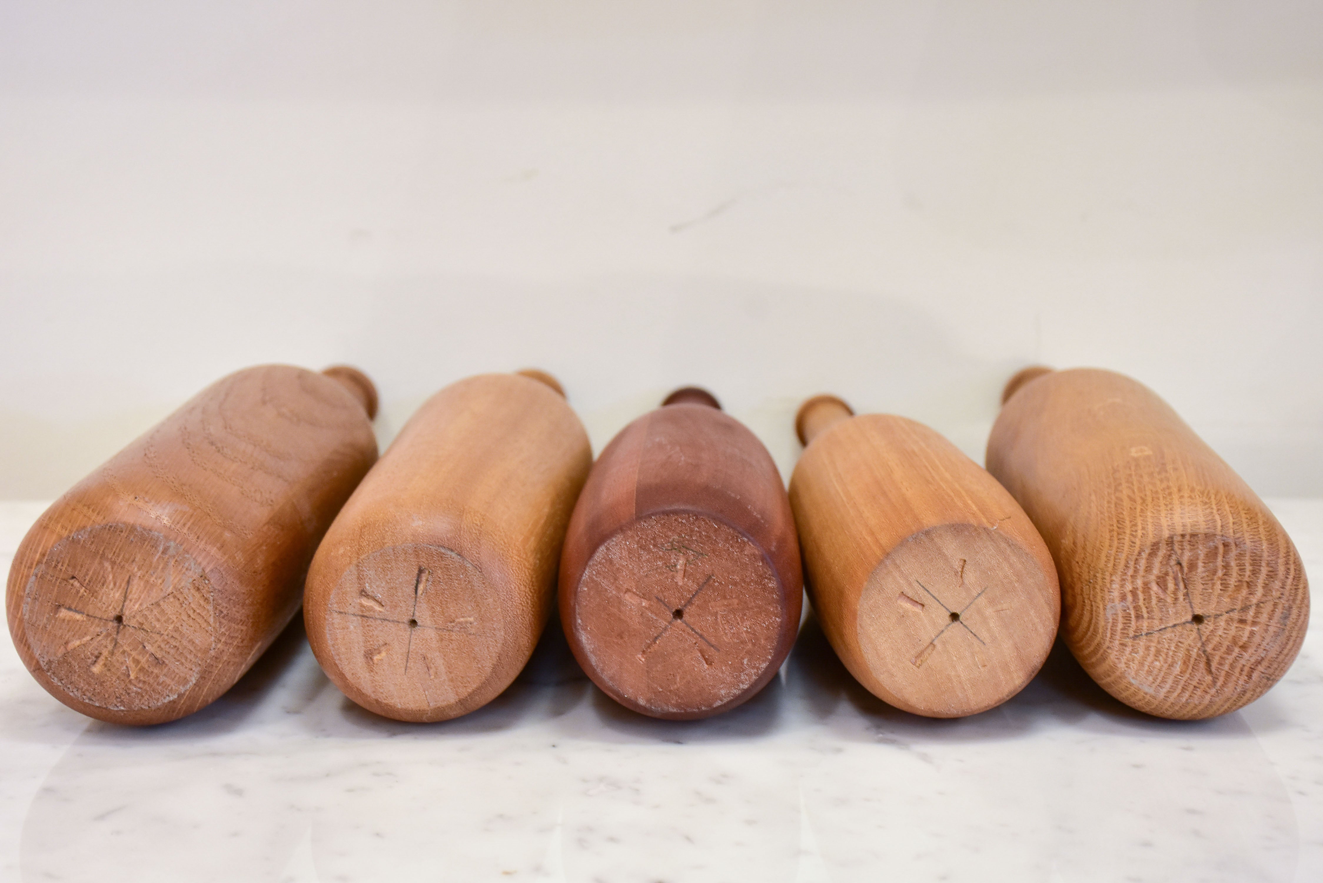 Collection of five wooden sculptures in the shape of bottles