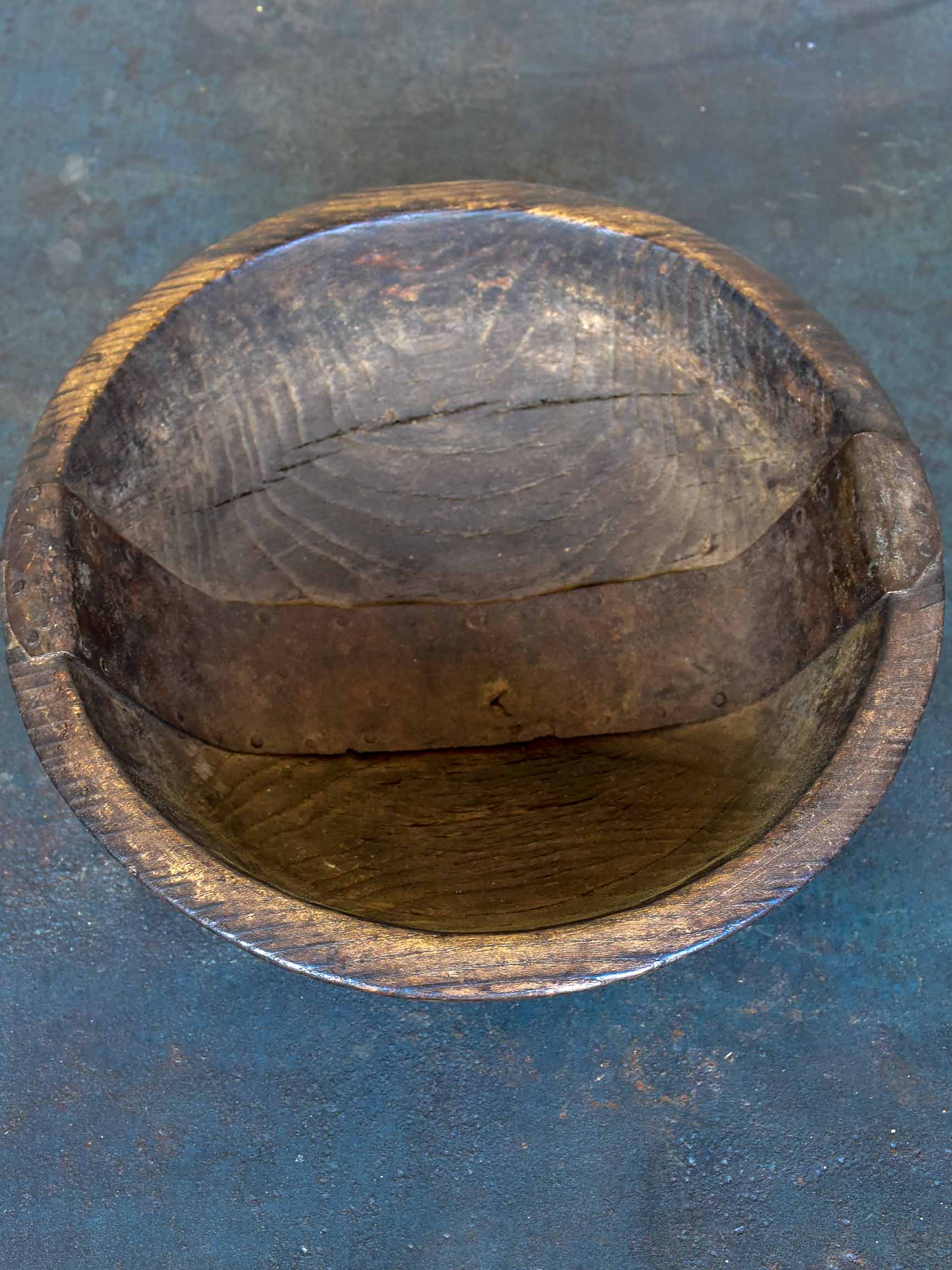 An antique French wooden bowl with repairs