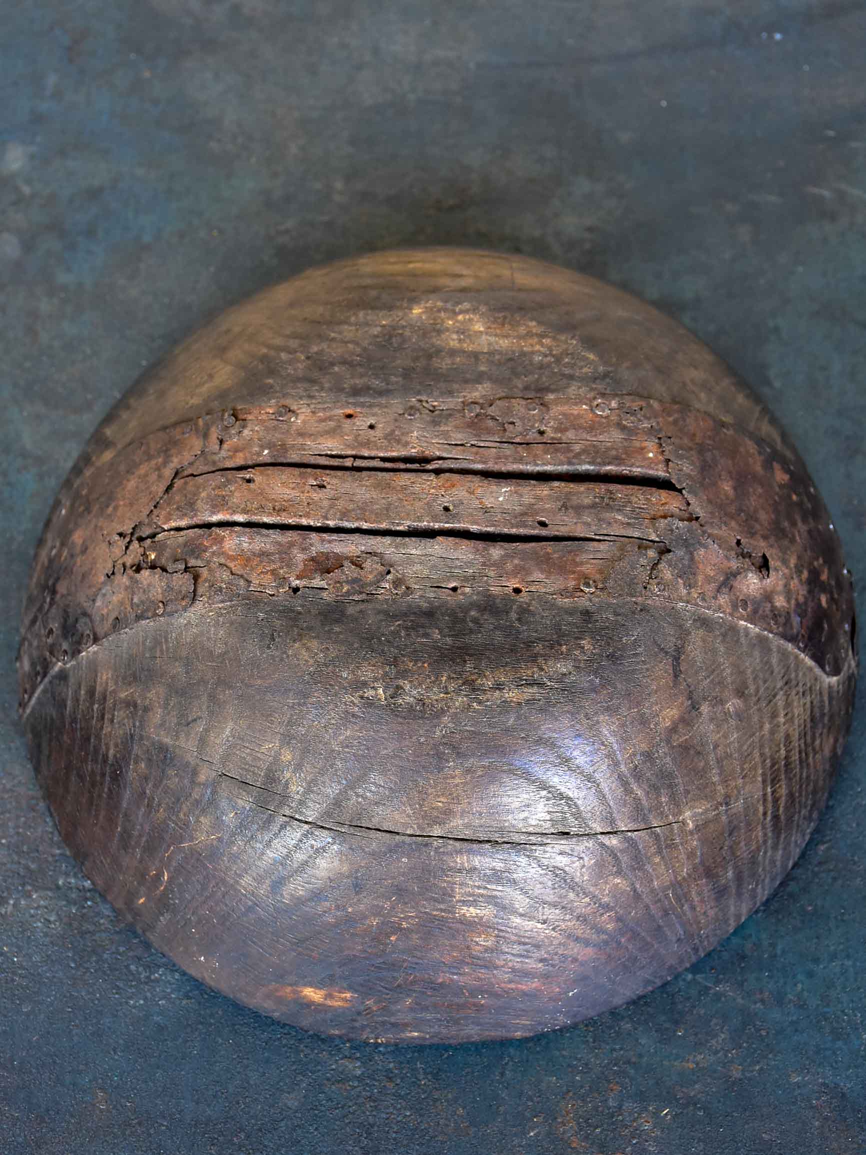 An antique French wooden bowl with repairs