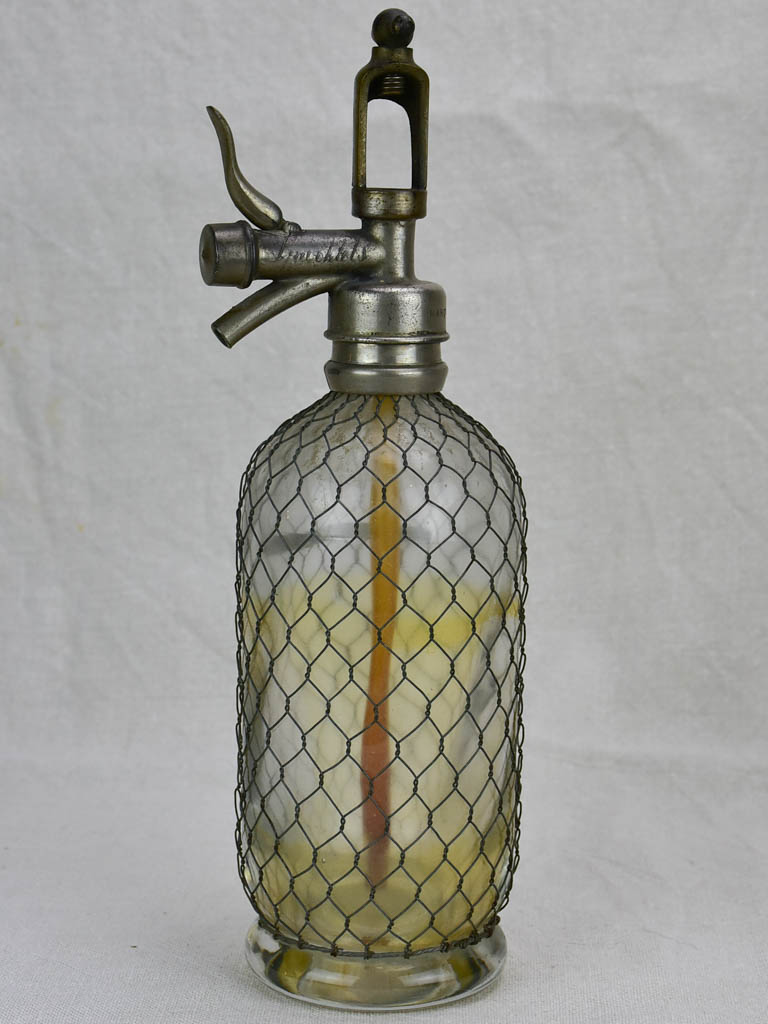 Antique French seltzer bottle in wire