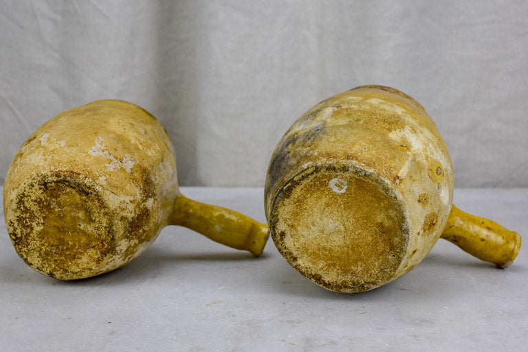 Two antique French cooking pots with one handle and yellow glaze